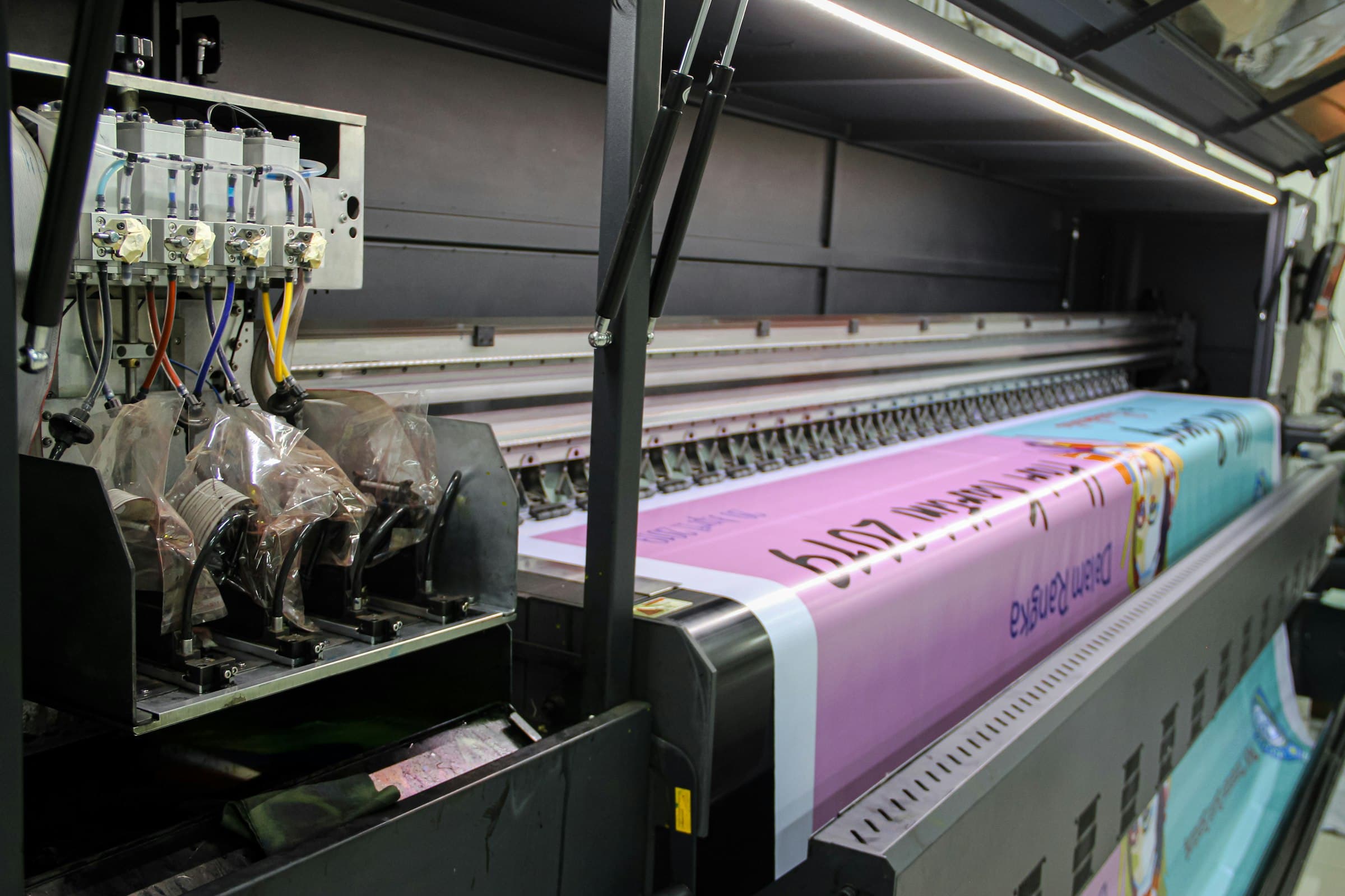 Wide-format industrial printer running a printed roll